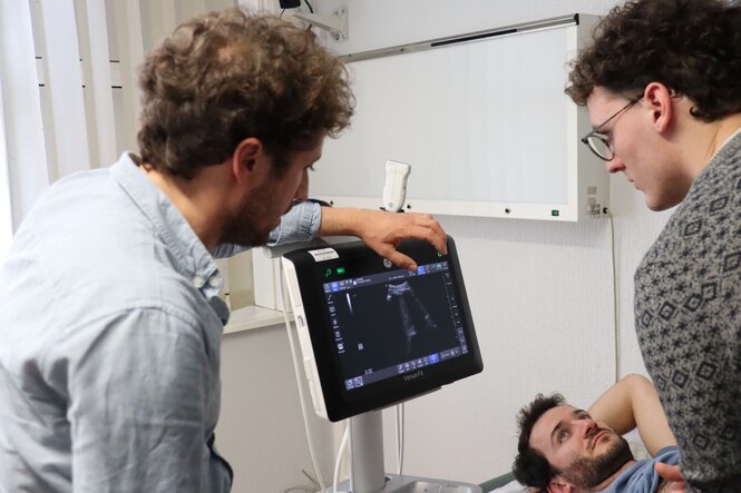 <strong>Échographie réelle</strong> <br> <em>Les apprenants s'exercent à l'échographie réelle sur leur camarade volontaire.</em> Échographie réelle