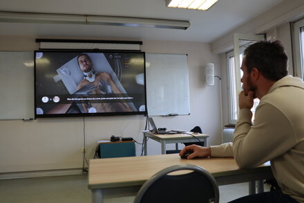 <strong>Présentation d'HemoSims : examen du patient</strong> <br> <em>Grâce à une vue à la première personne, HemoSims permet d'examiner le patient virtuel dans l'ordre indiqué par le formateur.</em> Présentation d'HemoSims : examen du patient