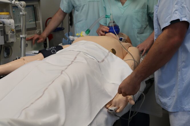 <strong>Installation du patient au bloc</strong> <br> <em>Les étudiants procèdent à l'installation du patient en s'assurant que tout est prêt avant opération.</em> Installation du patient au bloc